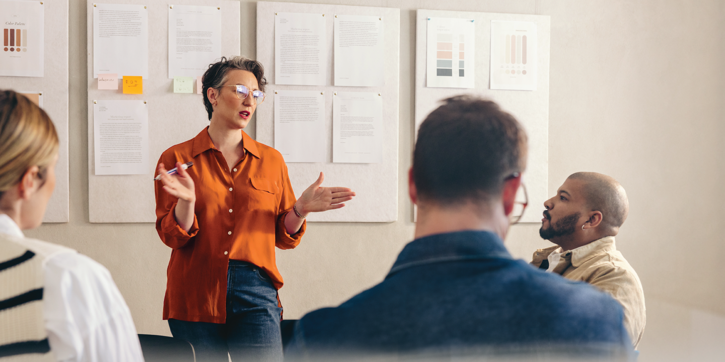 Woman talking to a group of people at a meeting